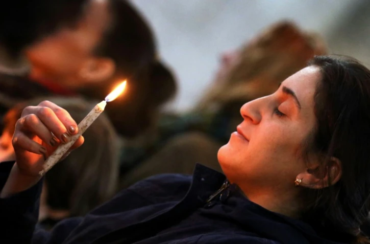 Une chrétienne irakienne tient un cierge lors de la messe de Noël à l'église Saint John de Qaraqosh, le 25 décembre 2016