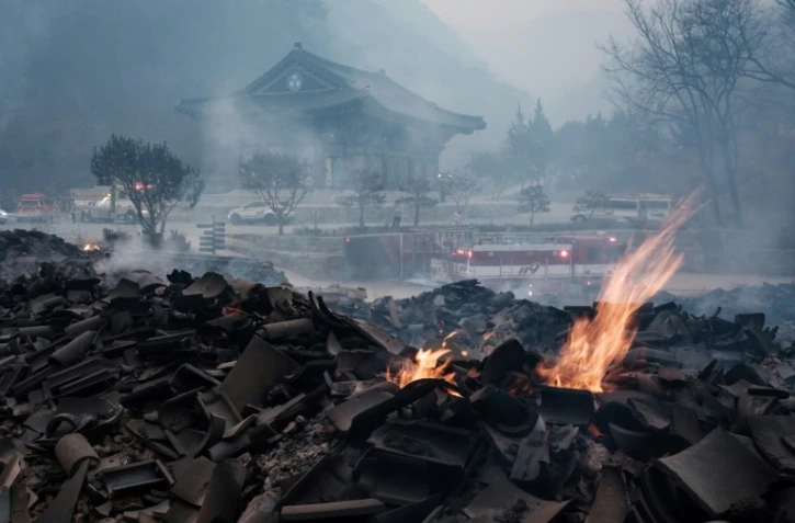 Des braises subsistent parmi les débris après que la plupart des bâtiments ont été réduits en cendres à la suite d'un feu de forêt au temple Gounsa à Uiseong, en Corée du Sud, le 26 mars 2025