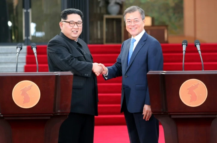 Le président sud-coréen Moon Jae-in (d) et le leader nord-coréen Kim Jong Un se serrent la main après avoir fait une déclaration commune lors du sommet interncoréen, le 27 avril 2018 à Panmunjom
