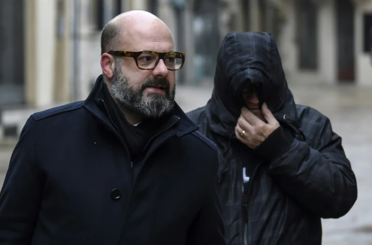 Marcel Jacob (d), le visage caché par sa capuche de blouson, arrive à la cour d'appel de Dijon, accompagné par son avocat Me Stephane Giuranna, le 4 décembre 2017