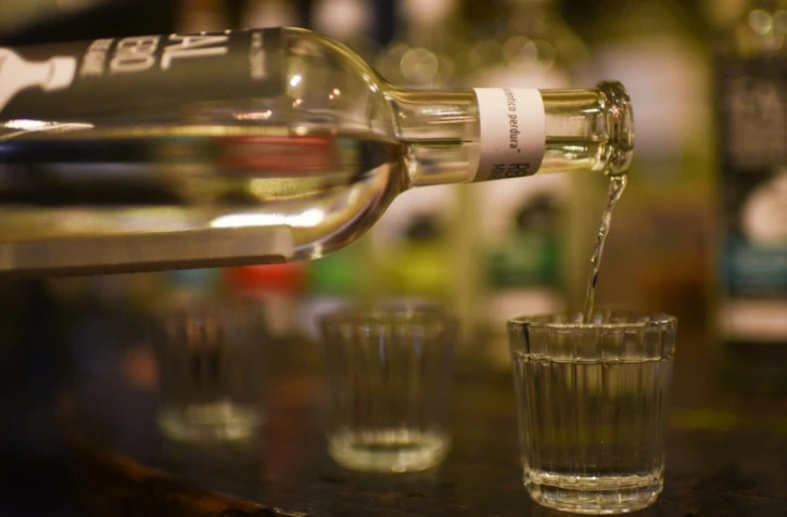 Graciela Angeles Carreno, qui dirige une entreprise familiale de quatre générations, sert des verres de mezcal dans leur usine de Real Minero, à Sata Catarina Minas, dans l'Etat d'Oaxaca, au Mexique, le 25 juillet 2022