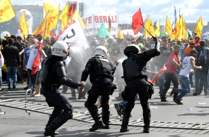 Des policiers anti-émeutes affrontent des manifestants opposés aux réformes du président Michel Temer, à Brasilia, le 24 mai 2017
