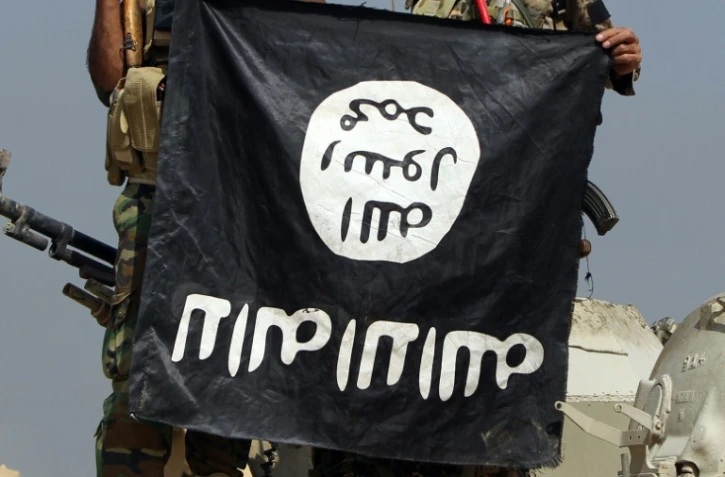 Le drapeau de l'Etat islamique brandi par des soldats irakiens après la conquête d'un territoire près de Baiji, en Irak le 19 octobre 2015