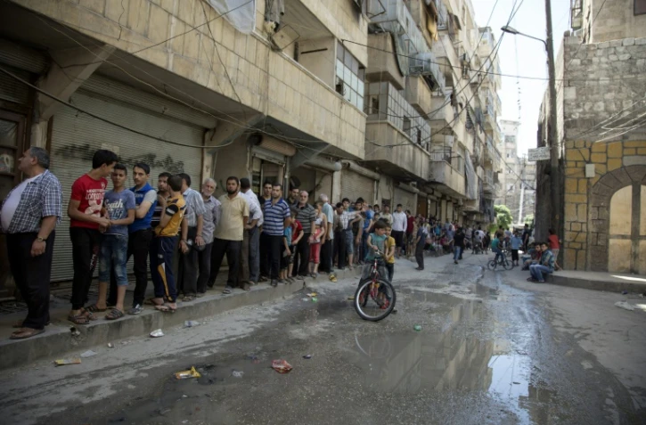 Des Syriens font la queue pour acheter du pain à Alep le 12 juillet 2016
