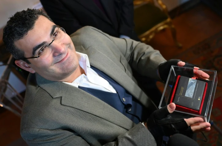 L'athlète libanais paraplégique Michael Haddad tient le livre "Pourquoi êtes-vous si craintifs?" du pape François le 17 décembre 2021 lors d'une conférence de presse à Rome