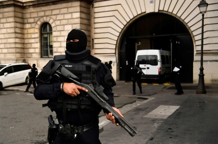 Un policier armé monte la garde devant le palais de Justice de Paris, alors qu'arrive le van transportant Jawad Bendaoud, le 24 janvier 2018