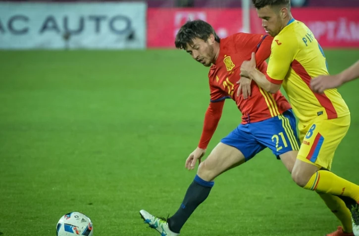 L'attaquant espagnol David Silva (g) à la lutte avec le milieu défensif roumain Doru Mihai Pintilii lors d'un match amical, le 27 mars 2016 à Cluj-Napoca (nord de la Roumanie)