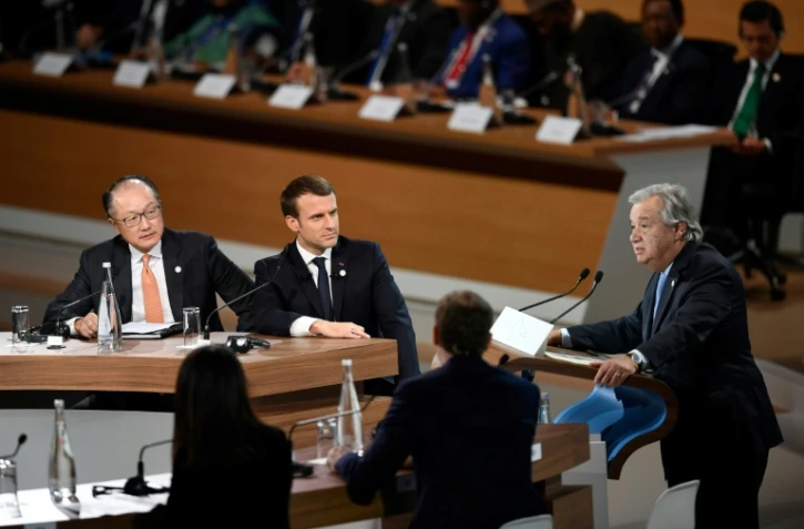 Le président de la Banque mondiale Jim Yong Kim et Emmanuel Macron écoutent le secrétaire général des Nations-Unies Antonio Guterres, à  l'île Seguin à Boulogne-Billancourt, à l'ouest de Paris le 12 décembre 2017
