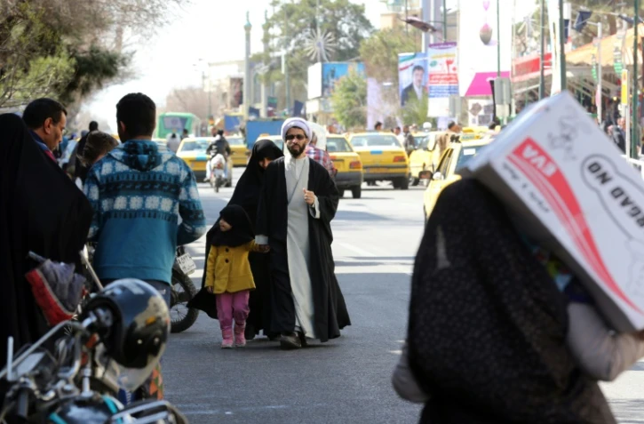 Un religieux iranien avec sa famille, le 24 février 2016 à Qom (130 km de Téhéran)