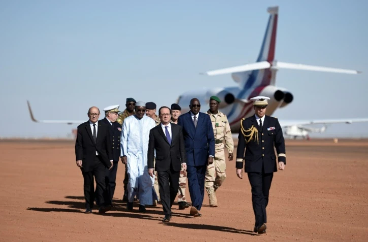 François Hollande (C), le Premier ministre malien Modibo Keita (3e D), le ministre français de la Défense Jean-Yves Le Drian (G), le 13 janvier 2017 lors de la visite aux troupes de l'opération antiterroriste Barkhane à Gao, dans le nord du Mali