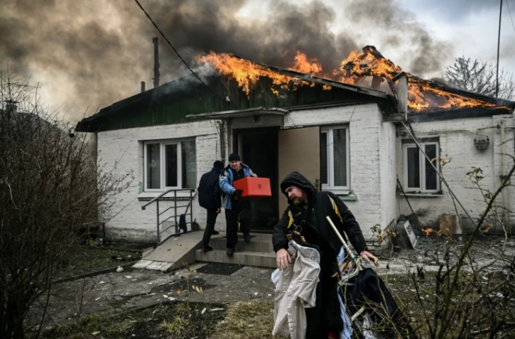 Des personnes sortent des affaires d'une maison en feu après un bombardement russe à Irpin, en Ukraine, le 4 mars 2022