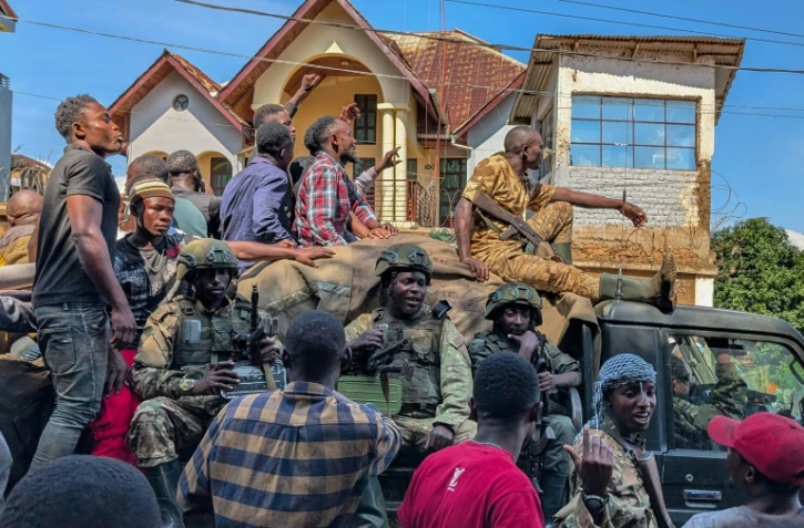 Des habitants de Bukavu aux côtés de combattants du M23 le 16 février 2025