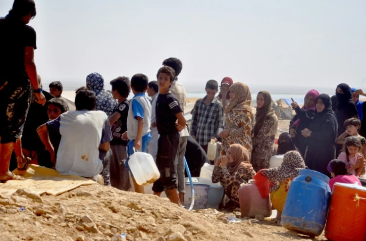 Des syriens de Deir Ezzor, dernière province contrôlée quasi-totalement par le groupe Etat islamique, où l'EI a récemment imposé l'enrôlement obligatoire, dans un camp de déplacés près d'Aricha, le 13 août 2017 