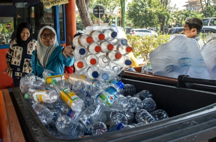 Des dizaines de personnes échangent des bouteilles en plastique contre des tickets à la gare routière de Surabaya, en Indonésie, le 21 juillet 2019