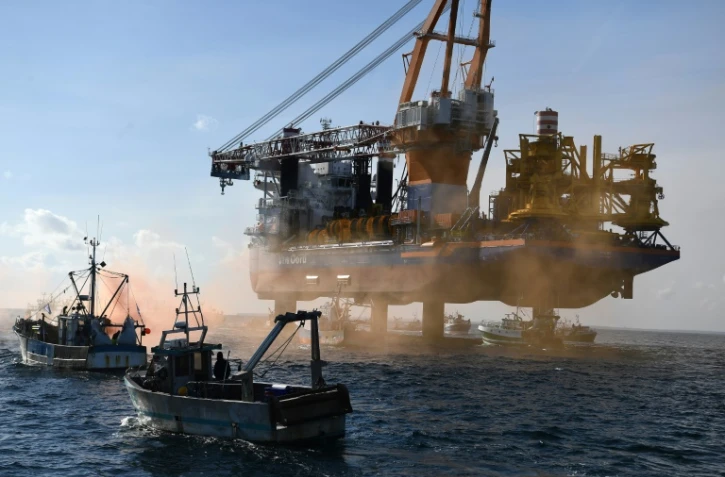 Des bateaux de pêche entourent un bâtiment, l'Aeolus, chargé de poser les fondations d'un chantier éolien, pour protester contre cette construction, le 7mai 2021 dans la baie de Saint-Brieuc