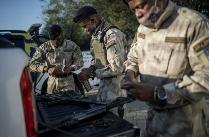 Une équipe de l'entreprise de sécurité privée Blue Hawk Tactical approvisionne ses armes avant une opération visant un site minier clandestin, près de Springs, en Afrique du Sud, le 28 avril 2021.