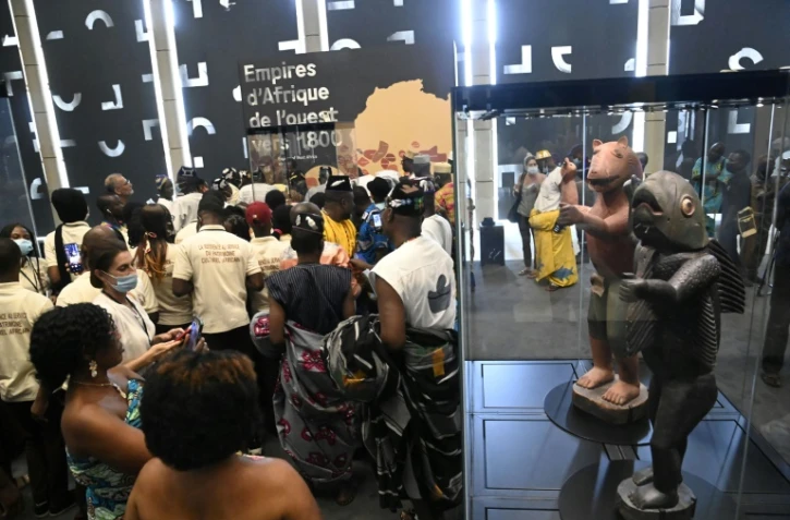 Des visiteurs découvrent des trésors restitués par la France au Bénin lors d'une exposition à Cotonou, le 20 février 2022