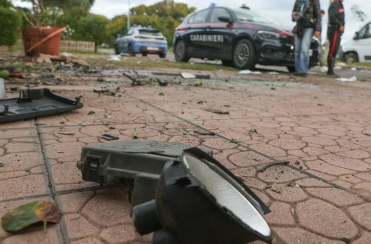 Des carabiniers italiens devant le domicile d'un journaliste d'enquête italien dont une bombe a fait exploser la voiture à Pomezia près de Rome, le 17 octobre 2025
