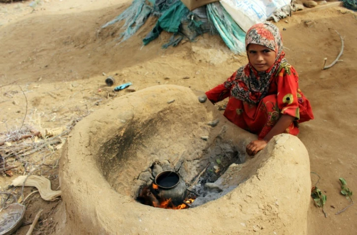 Une petite fille yéménite qui a fui la guerre dans la région de Harad, fait bouillir de l'eau dans un camp de déplacés à Abs dans la province de Hajjah, le 23 juillet 2017 