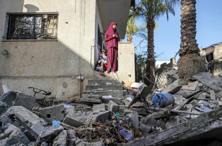 Une femme palestinienne constate les dommages subis par la maison familiale à Nuseirat (centre), le 23 mai 2024, à la suite des bombardements israéliens sur la bande de Gaza