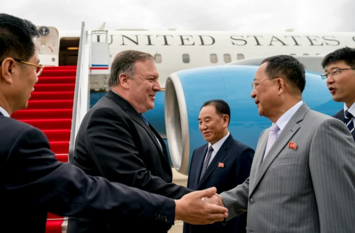 Le secrétaire d'Etat américain Mike Pompeo (g) est accueilli par son homologue nord-coréen Ri Yong Ho (2e d) et par Kim Yong Chol (c), le bras droit de Kim Jong Un, à son arrivée à l'aéroport de Pyongyang, le 6 juillet 2018 en Corée du Nord