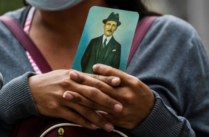 Une femme tient dans ses mains une image de José Gregorio Hernandez (1864-1919), "le médecin des pauvres", héros national vénézuélien, pendant la créméonie de béatification le 30 avril 2021 à Caracas