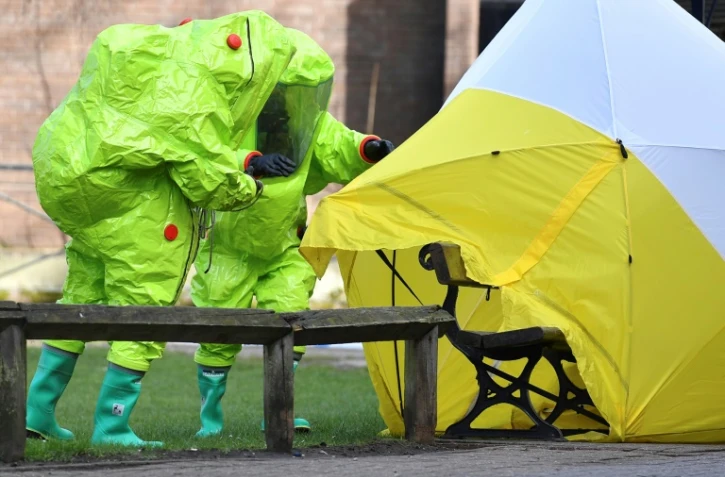 Des membres des services d'urgence installent une tente de protection, le 8 mars 2018 à Salisbury, sur le banc où l'ex-espion russe Sergueï Skripal et sa fille Ioulia ont été retrouvés inconscients