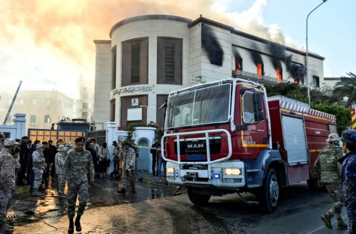 Un camion de pompiers et des responsables de la sécurité à l'extérieur du ministère des Affaires étrangères libyen à Tripoli, la capitale, où a eu lieu une attaque, le 25 décembre 2018