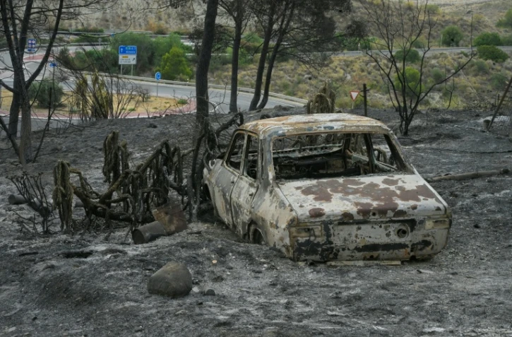 Une voiture calcinée dans une zone touchée par un incendie de forêt meurtrier à Almocaizar, dans la province d'Almería, le 12 juillet 2026 en Espagne
A wildfire that has killed at least 12 people in southern Spain was close to being brought under control Sunday, allowing hundreds of evacuated residents to return home as firefighters worked to fully stabilise the blaze, offficials said. Authorities have kept the death toll at 12 and cautioned that the number of missing people remains uncertain until autopsies and the identification of recovered bodies are completed.