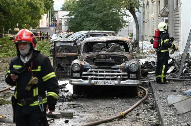 Des pompiers dans la ville ukrainienne de Lviv, le 12 juillet 2025, après une attaque massive russe aux drones et missiles contre le pays