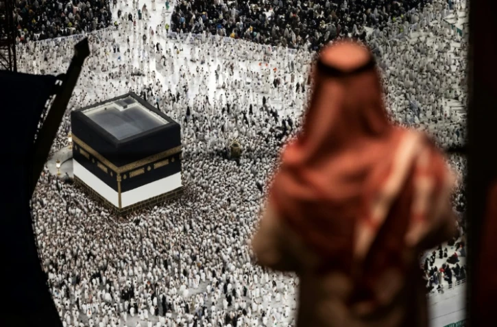 Un homme regarde les fidèles musulmans marcher autour de la Kaaba, le sanctuaire le plus sacré de l'Islam, à la Grande Mosquée de La Mecque, ville sainte de l'Arabie saoudite, le 13 juin 2024