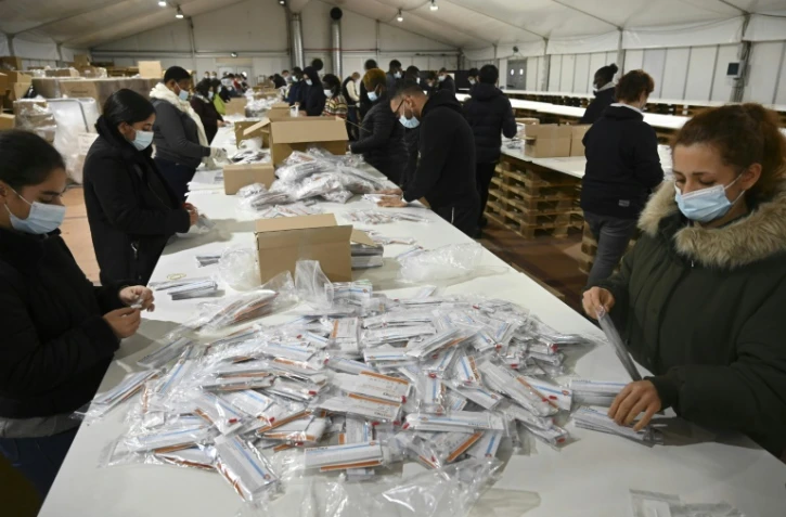 Des opérateurs assemblent des autotests de diagnostic rapide du Covid-19 sous un chapiteau dressé sur le parking de Biosynex, à Illkirch-Graffenstaden, le 29 décembre 2021.
