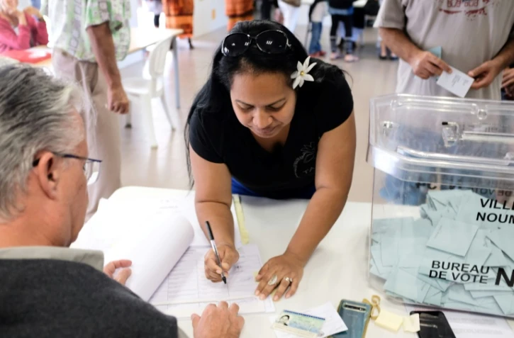 Une femme vote dans un bureau à Nouméa le 4 octobre 2020
