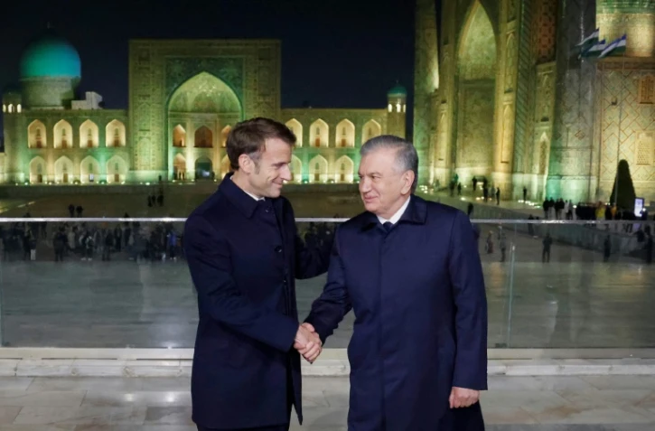 Le président français Emmanuel Macron, en visite officielle, serre la main de son homologue ouzbek Chavkat Mirzioïev sur la place du Régistan à Samarcande le 1er novembre 2023