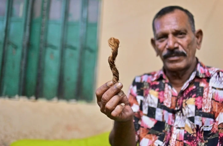 Le bourreau Shahjahan Bouya montre un morceau de corde de manille utilisée pour pendre les condamnés, lors d'une interview avec l'AFP chez lui à Keraniganj, dans la banlieue de Dacca, le 19 octobre 2023 au Bangladesh