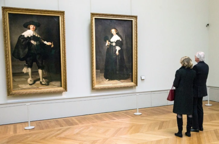 Des visiteurs contemplent deux tableaux de Rembrandt au Louvre, le 10 mars 2016