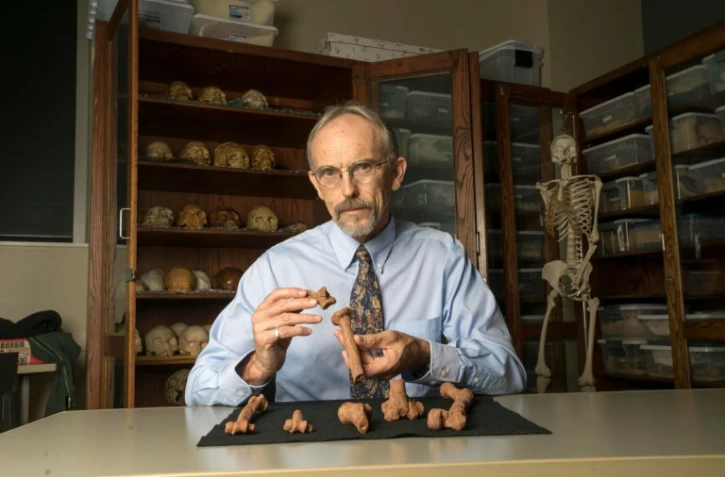 Portrait du professeur John Kappelman tenant une reproduction 3D du squelette de Lucy