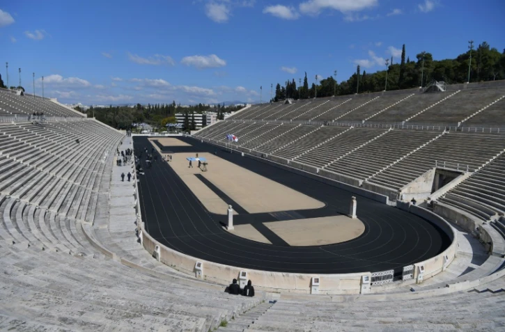 Cérémonie de transmission de la flamme olympique au Japon par la Grèce devant les tribunes vides du stade panathénaïque le 19 mars 2020 à Athènes 