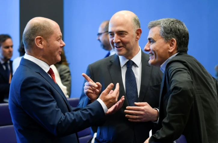 Le ministre allemand des Finances Olaf Scholz discute avec le commissaire européen aux Affaires financières et le ministre grec des Finances Euclid Tsakalotos (R) lors d'une réunion de l'eurogroupe à Luxembourg le 21 juin 2018. 
