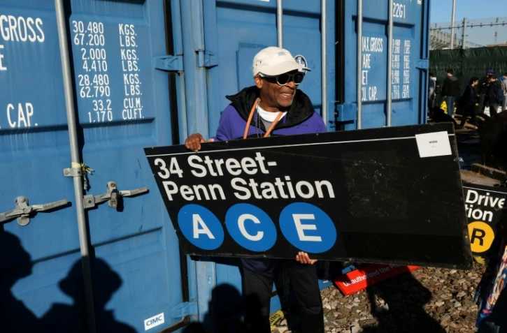 Le réalisateur Spike Lee tient une panneau d'une station de métro qu'il vient d'acheter lors de la vente annuelle organisée par la régie des transports de New York (MTA), le 9 octobre 2026