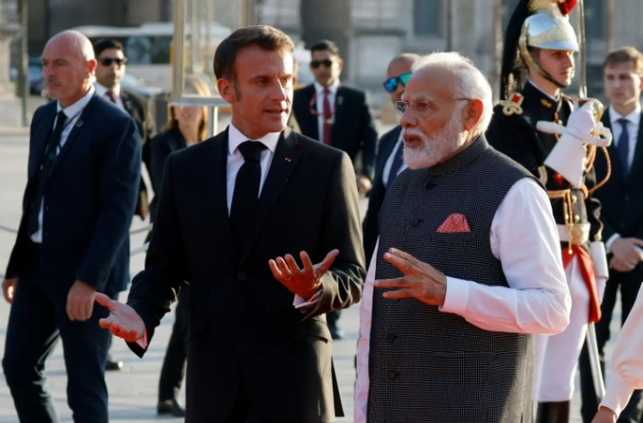 Le président Emmanuel Macron (g) acccueille le Premier ministre indien Narendra Modi au musée du Louvre pour un dîner, le 14 juillet 2023 à Paris