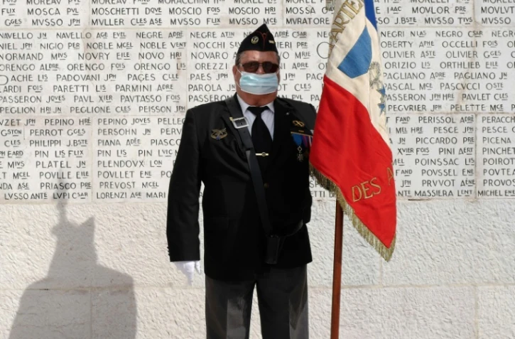 Un vétéran tient le drapeau français devant le monument aux morts à Nice, le 8 mai 2020 pour célébrer la fin de la Seconde guerre mondiale