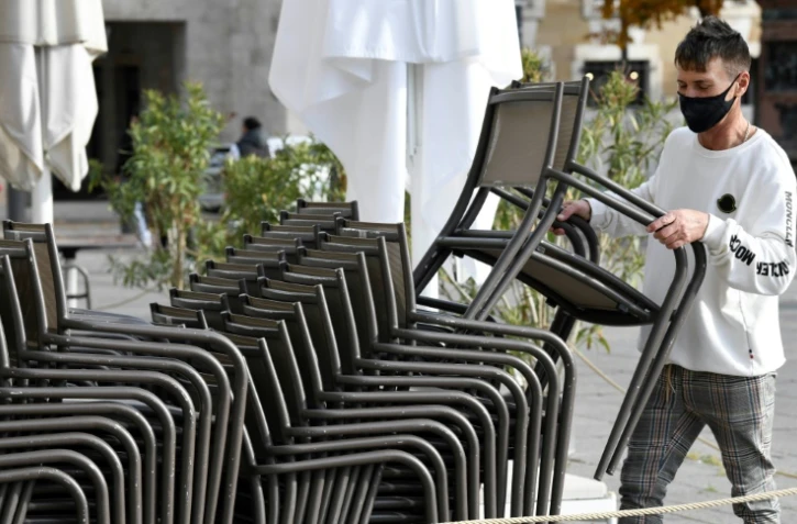 Le propriétaire d'un café de Stuttgart en Allemagne empile les chaises en raison de la fermeture de son établissement le 2 novembre 2020