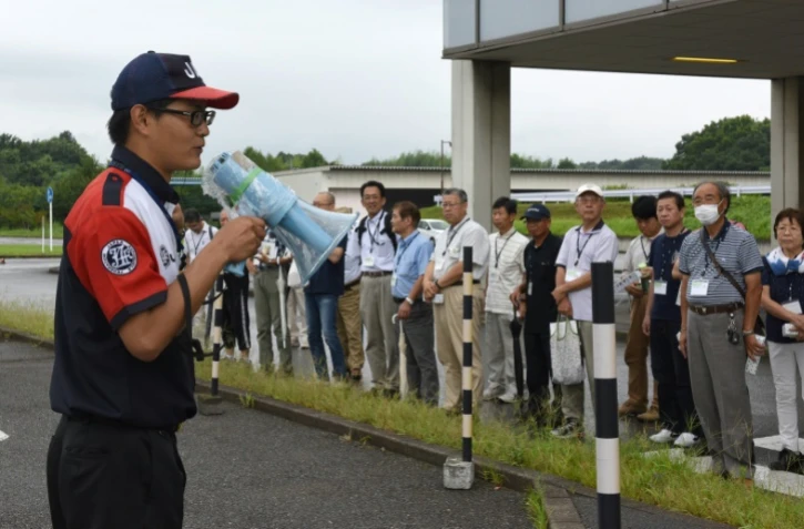 Un instructeur s'adresse à des participants à un stage de conduite pour seniors organisé par la Japan Automobile Federation (JAF), à Kanuma le 23 juillet 2017