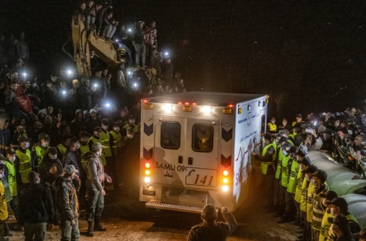 Les forces de sécurité contiennent la foule pour laisser passer l'ambulance transportant le corps du petit Rayan, retrouvé mort cinq jours après être accidentellement tombé dans un puits à Ighrane, le 5 février 2022 dans le nord du Maroc