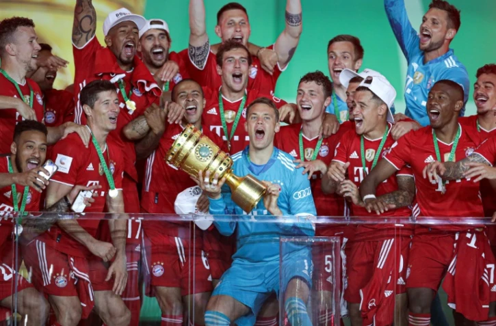 Le gardien du Bayern, Manuel Neuer (c), brandit le trophée de la Coupe d'Allemagne et célèbre avec ses coéquipiers la victoire en finale face à Leverkusen, à Munich, le 4 juillet 2020