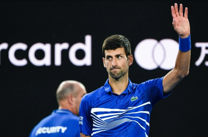 Le Serbe Novak Djokovic bras levé après sa victoire face au Japonais Kei Nishikori en quarts de finale de l'Open d'Australie, le 23 janvier 2019 à Melbourne
