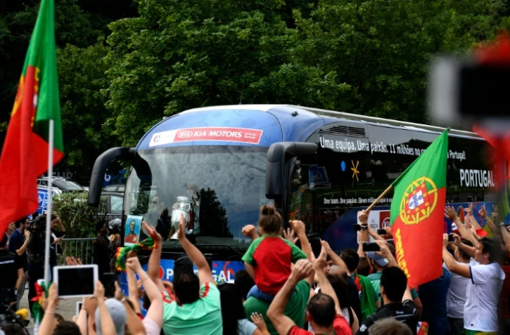 Les supporters portugais rendent hommages aux champions d'Europe qui quittent Marcoussis en bus pour prendre l'avion du retour au pays, le 11 juillet 2016