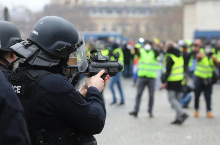 Un policier vise des manifstants avec un LBD, place de l'Etoile à Paris le 12 janvier 2019