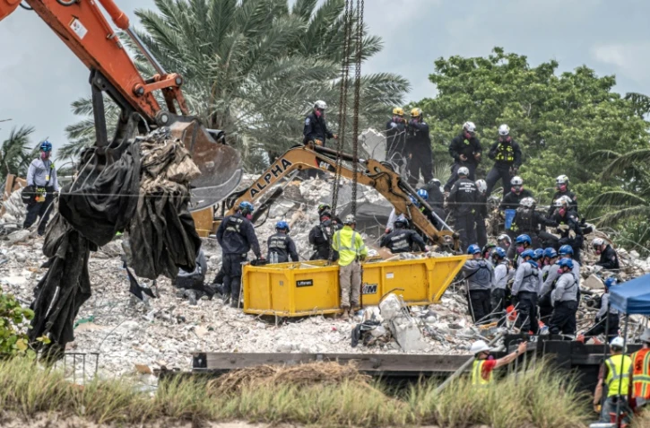 Des secouristes venus de tous les Etats-Unis, du Mexique et d'Israël s'affairent sur les décombres d'un immeuble effondré en Floride onze jours plus tôt, le 6 juillet 2021 